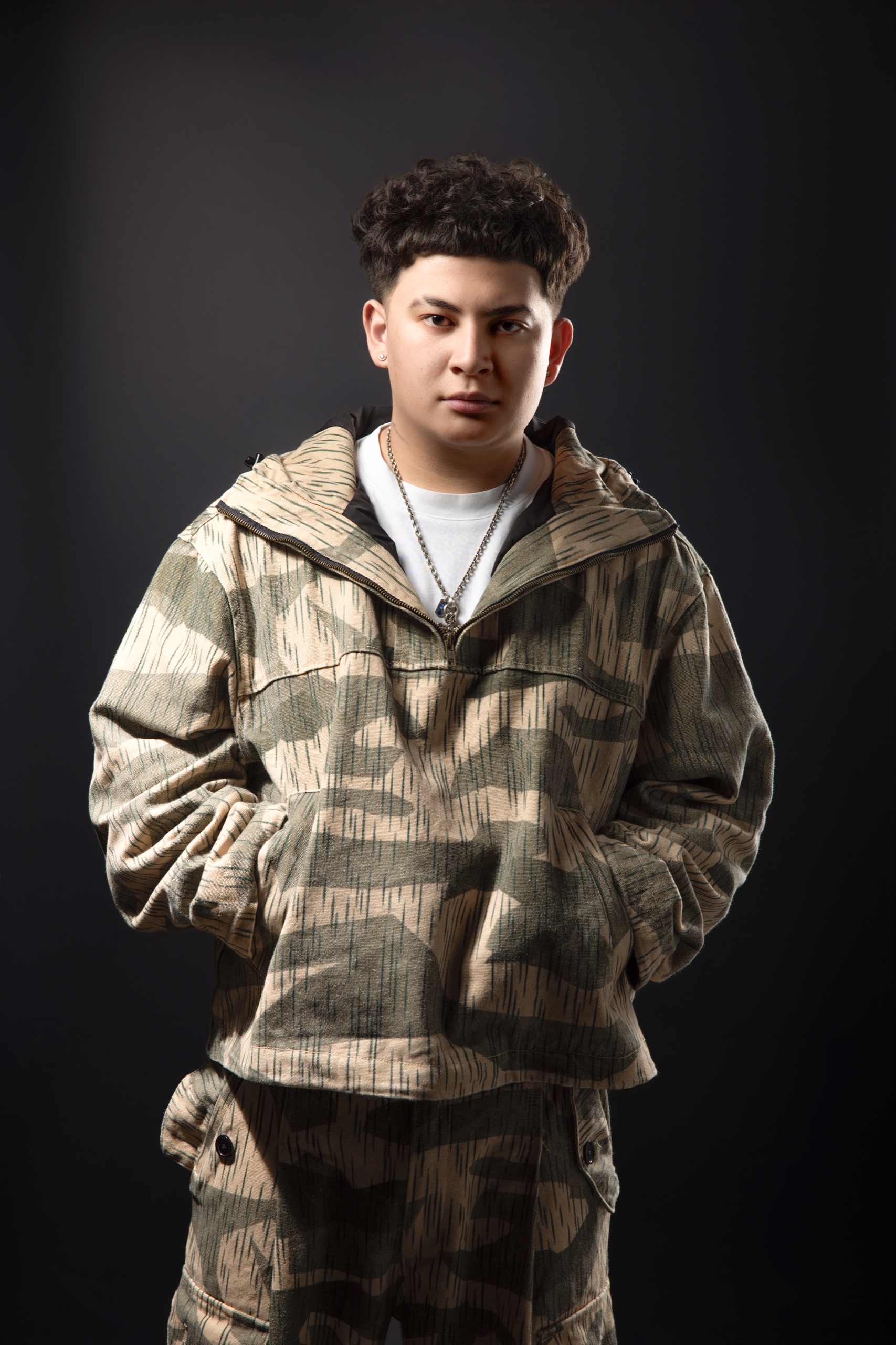 Karri photographed in a patterned jacket against a dark studio background