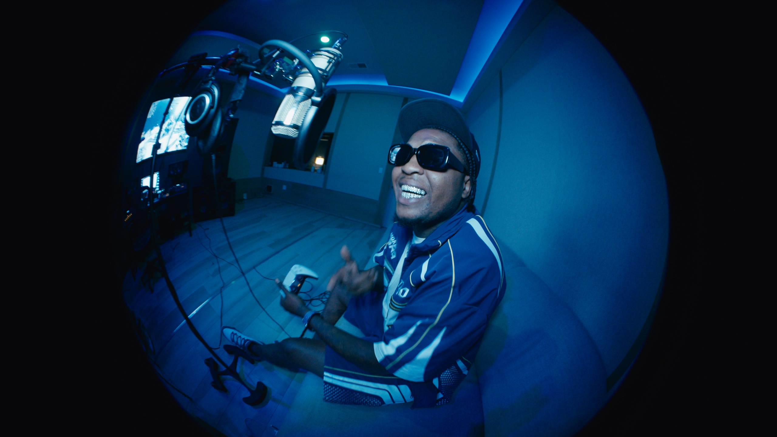 Loco Los recording beneath a microphone in a blue-lit studio